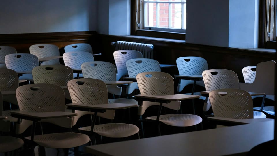 Rows of empty chairs and desks in a classroom
