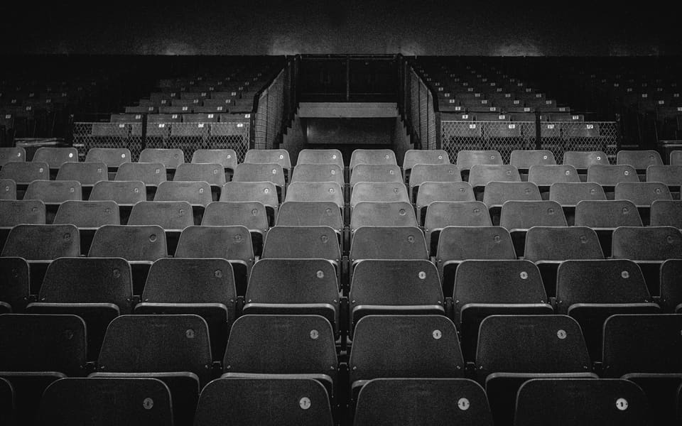 Empty rows of seats in a dark auditorium