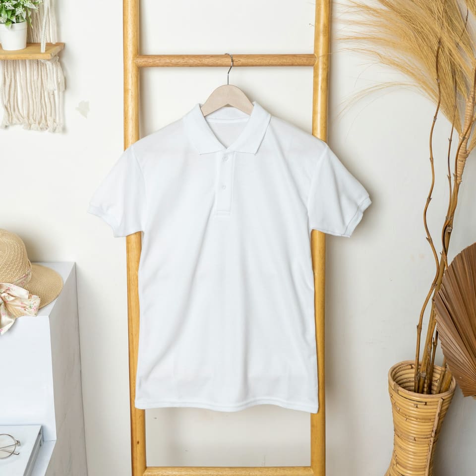 A plain white polo shirt on a hanger