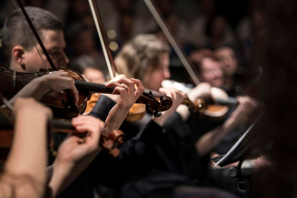 Violinists playing in a dimly lit room